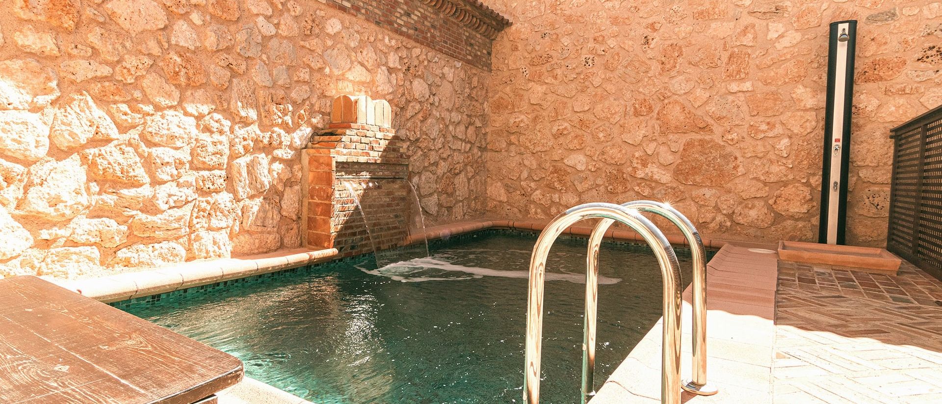 Piscina de la casa entre muros de piedra