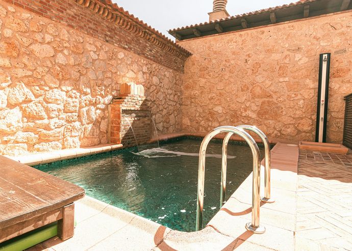 Piscina de la casa entre muros de piedra
